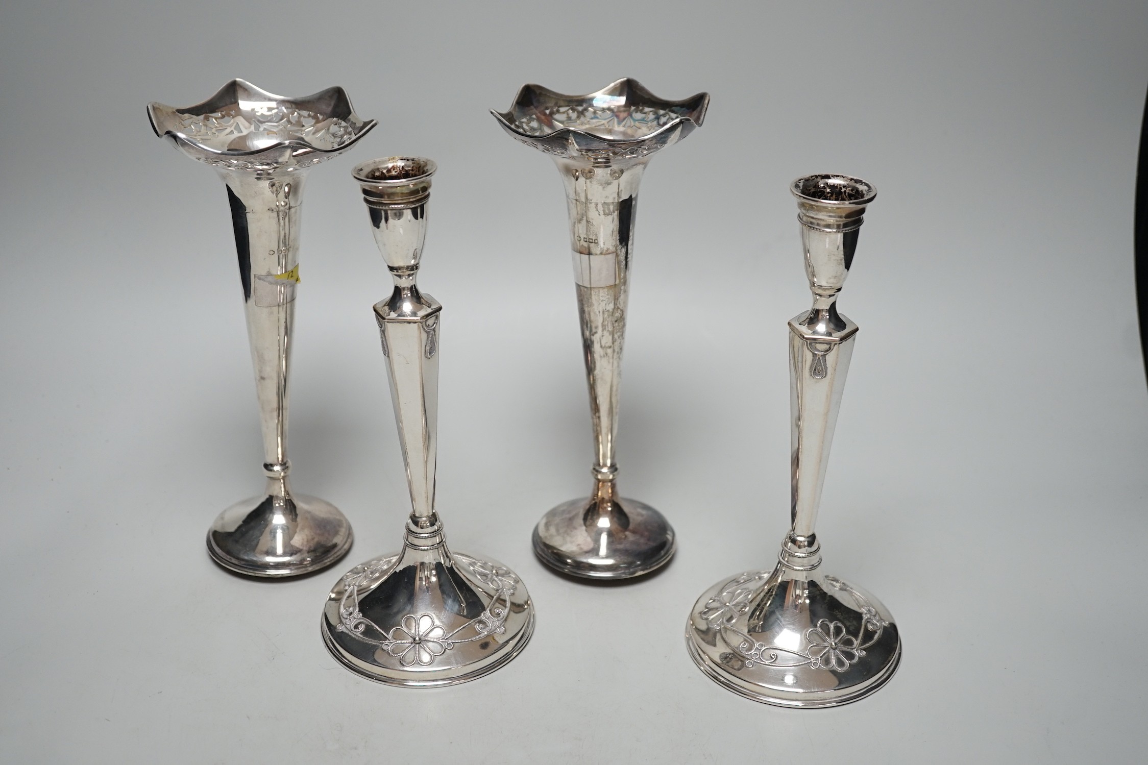A pair of George V silver mounted posy vases, 22.3cm, weighted and a pair of German 800 standard white metal mounted candlesticks, weighted.